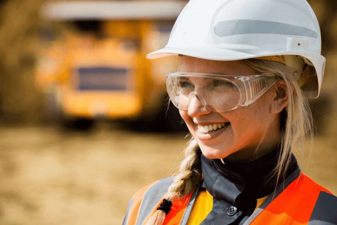 Woman in hard hat and goggles smiling